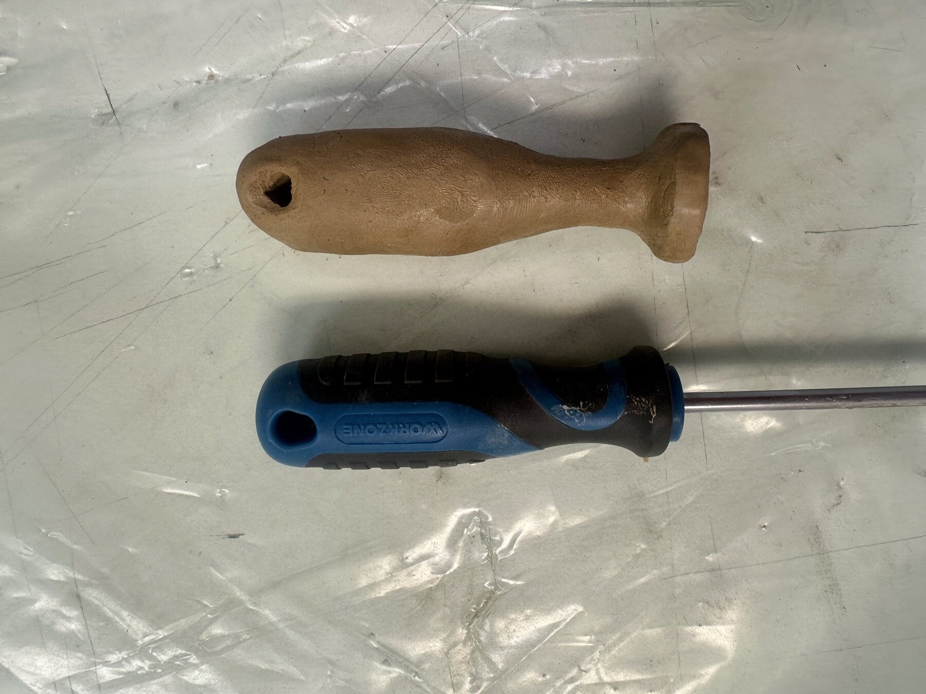 Clay replica of a screwdriver handle, next to the real screwdriver